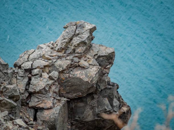 Rocky Cliff against the blue waters of El Yeso dam stock photo