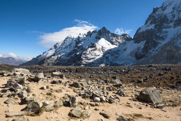 Rocky paths and green valleys surrounded by snowcapped mountains on the Salkantay Trek stock photo