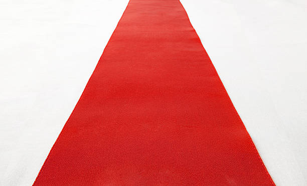 A roll of red carpet laid out on the floor stock photo