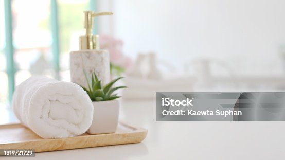 istock Roll up of white towels on white table with copy space Spa concept 1319721729
