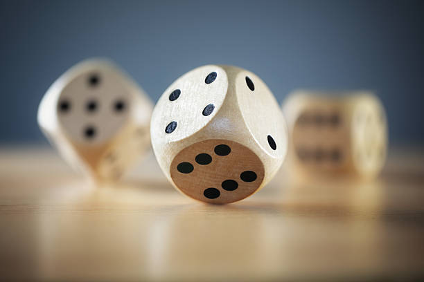 Rolling the dice Rolling three dice on a wooden desk dice photos stock pictures, royalty-free photos & images