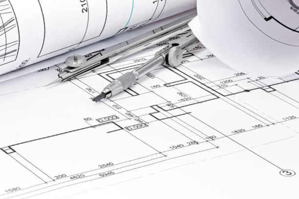 rolls of architecture blueprint with drawing compass closeup stock photo