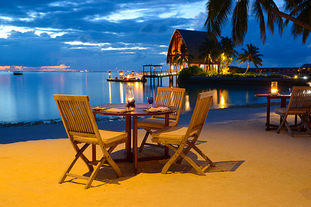 romantic candlelight beach dinner at seaside restaurant - sunset dining stockfoto's en -beelden