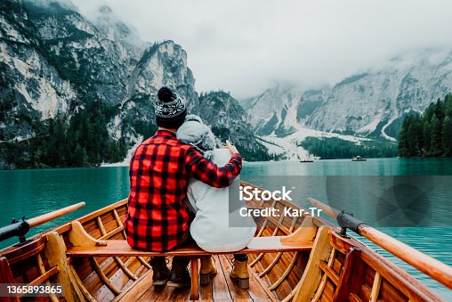 istock Romantic couple on a boat visiting an alpine lake at Braies Italy. Tourist in love spending loving moments together at autumn mountains. Concept about travel, couple and wanderust. 1365893865