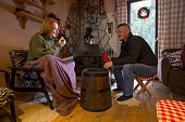Happy romantic couple sitting in mountain log cabin in winter , relaxing next to the fireplace. Photo is taken with full frame dslr camera indoors