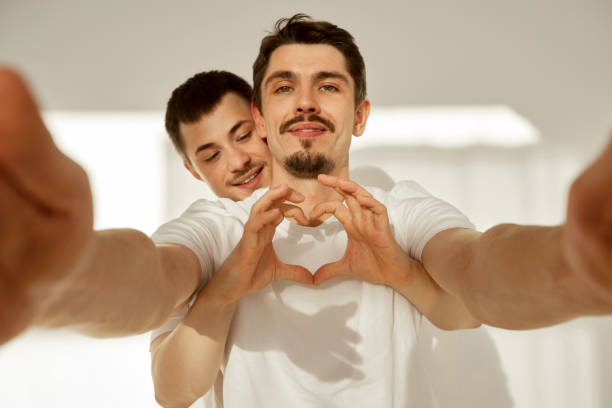 Romantic gay couple taking selfie at home stock photo