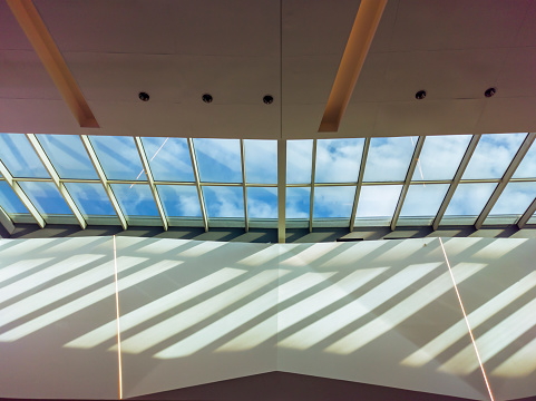 Modern building ceiling with a large skylight showing a blue sky through it
