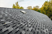 istock roof of new house with shingles roof-tiles and ventilation window 1334926091