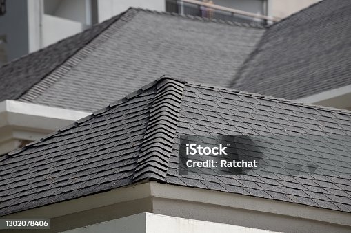 istock roof shingle background and texture. dark asphalt tiles on the roof. 1302078406