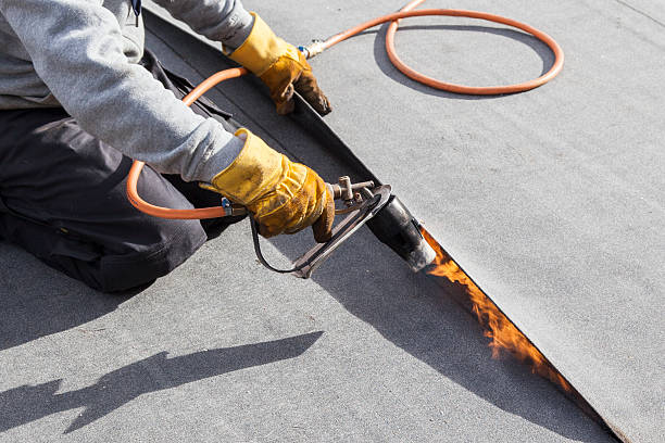 roofer burning asphalt felts on the garage roof - dak coating stockfoto's en -beelden