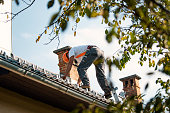 istock Roofer measuring chimney on roof top 1295220919