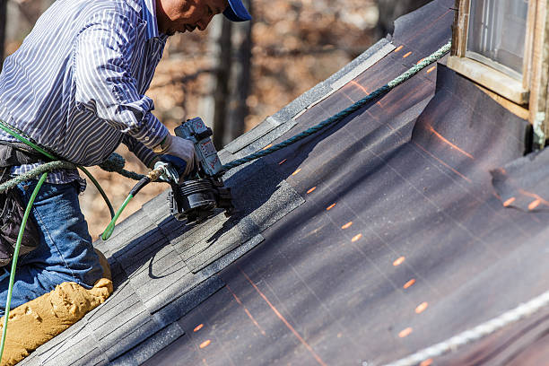 roofer uses nail gun to secure shingles picture