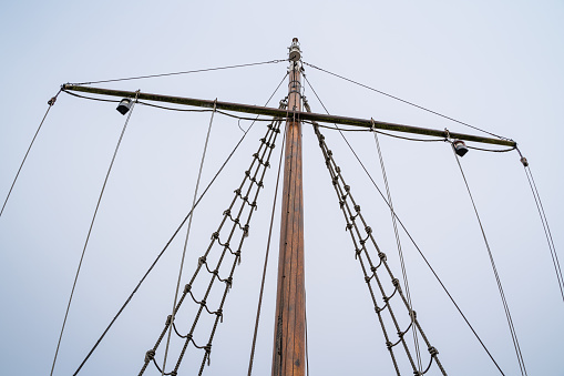 Ropes and rope ladder on a sailing ship with cloudy sky in the background