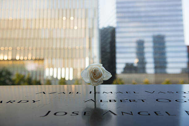 Rose at 9-11 Memorial at Ground Zero, New York City New York City, USA - July 6, 2016: A rose is left at the National September 11 Memorial at Ground Zero in Lower Manhattan, New York City. 911 memorial stock pictures, royalty-free photos & images