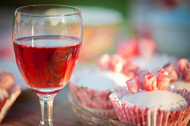 Rose cupcake and glass with red wine. stock photo