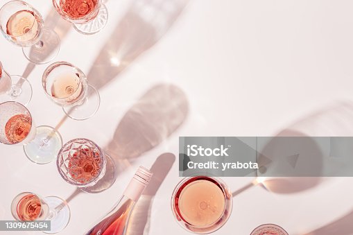 istock Rose wine assortment in crystal glasses, bottle of rose champagne sparkling wine with daylight and shadows. 1309675454
