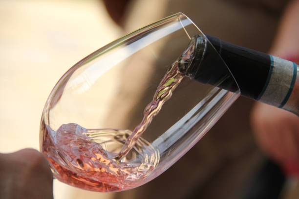 Rose wine being poured into a glass during an outdoor party Wine tasting and oenology school. Detail of wine poured into a goblet. rose wine stock pictures, royalty-free photos & images