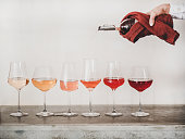istock Rose wine shades and womans hand pouring wine to glass 1214136125