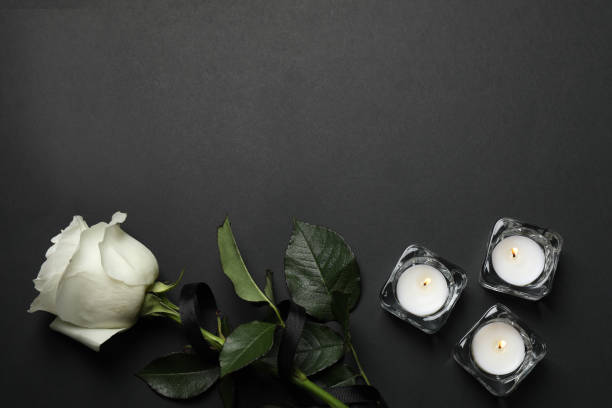 Rose with black ribbon and candles on dark background, flat lay. Space for text Rose with black ribbon and candles on dark background, flat lay. Space for text funeral parlor stock pictures, royalty-free photos & images