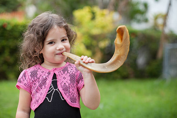 Little girl blowing shofar for Rosh Hashana