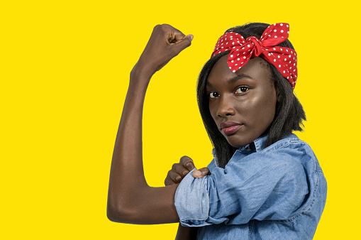 Beautiful woman dressed as the iconic Rosie the Riveter