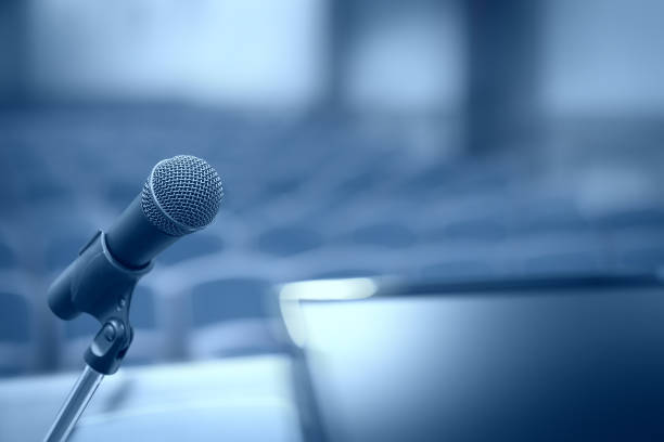 Rostrum with microphone and computer in conference hall with motion blur effect stock photo