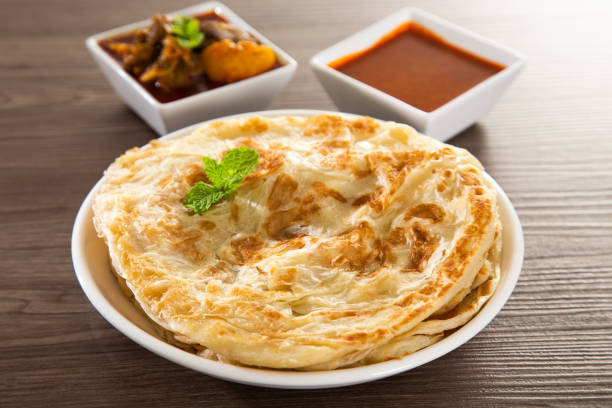 Roti Parata or Roti canai with lamb curry sauce - popular Malaysian breakfast Roti Parata or Roti canai with lamb curry sauce - popular Malaysian breakfast chapatti stock pictures, royalty-free photos & images