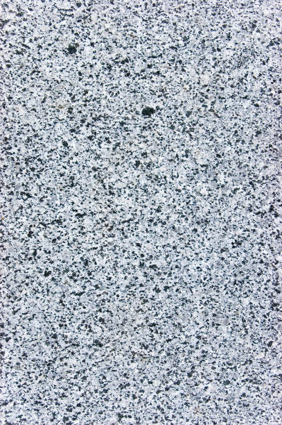 Rough cut natural grey granite stone texture pattern, vertical background, coarse spotted gray macro closeup copy space stock photo