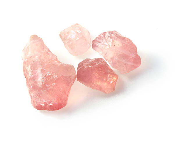 Rough rose quartz gemstones. Closeup picture of semiprecious raw rose quartz gems isolated on white background. rose quartz stock pictures, royalty-free photos & images