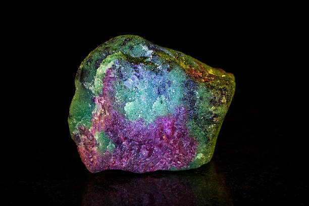 Rough ruby with Zoisite in front of black uncut ruby and zoisite, black background zoisite stock pictures, royalty-free photos & images