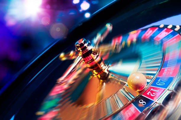roulette wheel in motion with a bright and colorful background - gokken stockfoto's en -beelden