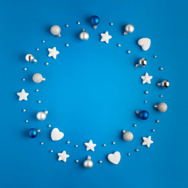 Round frame made of christmas baubles and decoration on blue background. stock photo