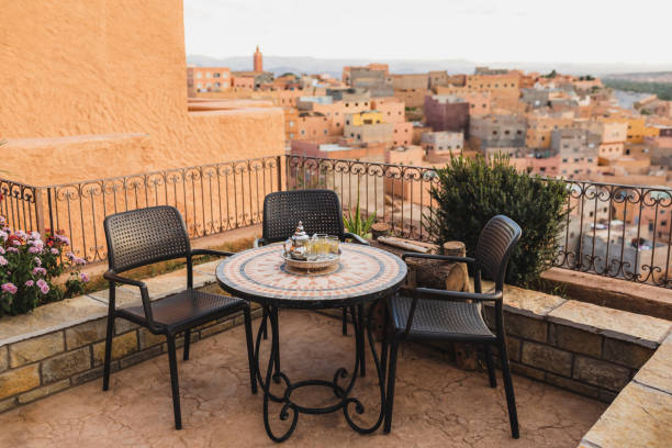 runder mosaiktisch auf der terrasse mit traditionellem marokkanischem minztee. erstaunliche aussicht auf die altstadt boumalne in marokko bei sonnenuntergang. - kannestein stock-fotos und bilder