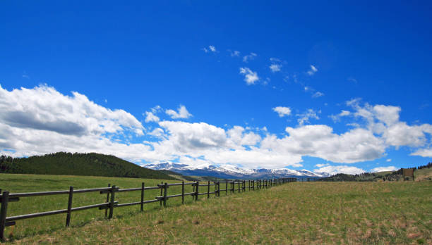 Round rail fence under blue sky in the Bighorn Mountain range of  Rocky Mountains in Wyoming USA stock photo