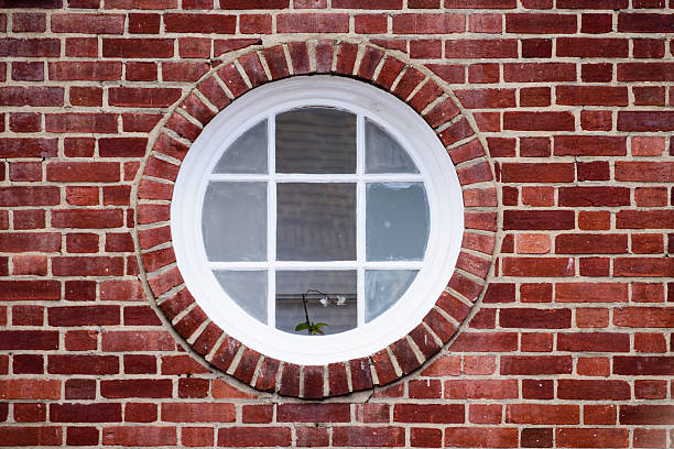 Round window in a brick wall stock photo