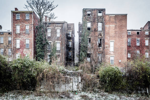 Row of abandoned buildings with overgrown vegetation stock photo