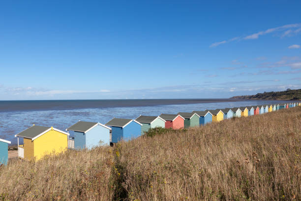 Row of colourful wooden beach huts. stock photo