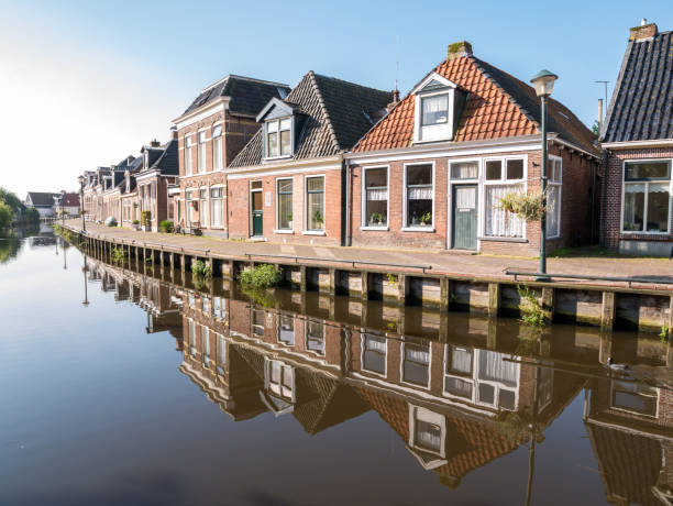 Row of houses reflecting in canal in Warga, Leeuwarden, Friesland, Netherlands stock photo