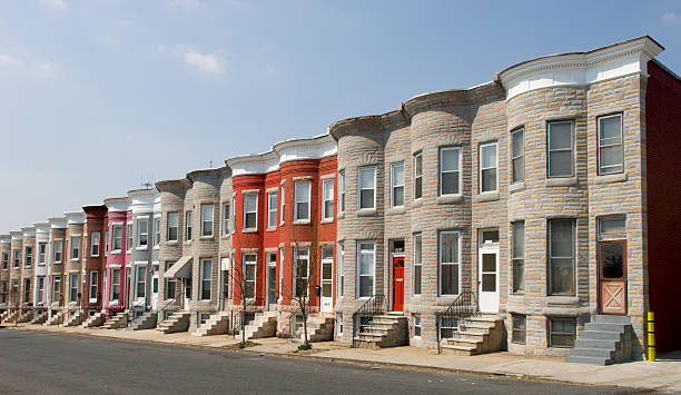 Row of identical houses on a street Colorful row houses along a sunny residential street. brownstone stock pictures, royalty-free photos & images