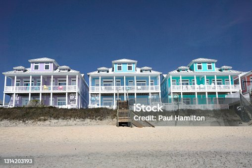 istock Row of multicolored houses on a sandy beach 1314203193