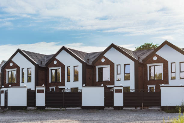 Row of new townhouses for sale or rent, against the blue sky stock photo