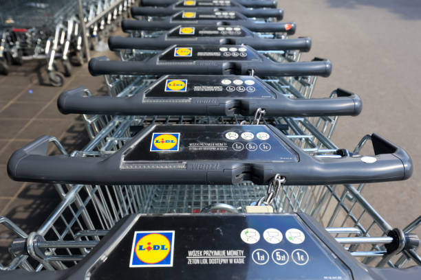 Row of stacked metal supermarket trolleys Warsaw, Poland - May 10, 2020: Row of stacked metal Lidl supermarket trolleys can be seen in perspective. This store is one of many German discount supermarket chains worldwide. lidl stock pictures, royalty-free photos & images