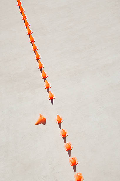 Row of traffic cones with one on side  imperfection stock pictures, royalty-free photos & images