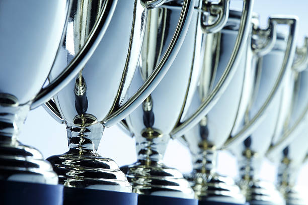 Row of trophies Close-up of a long row of trophies. Shot with shallow depth of field. trophy award stock pictures, royalty-free photos & images