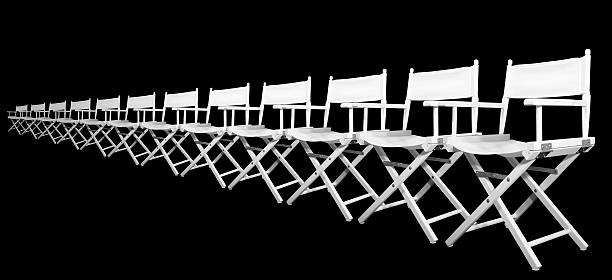 Row of white directors chairs on black background stock photo