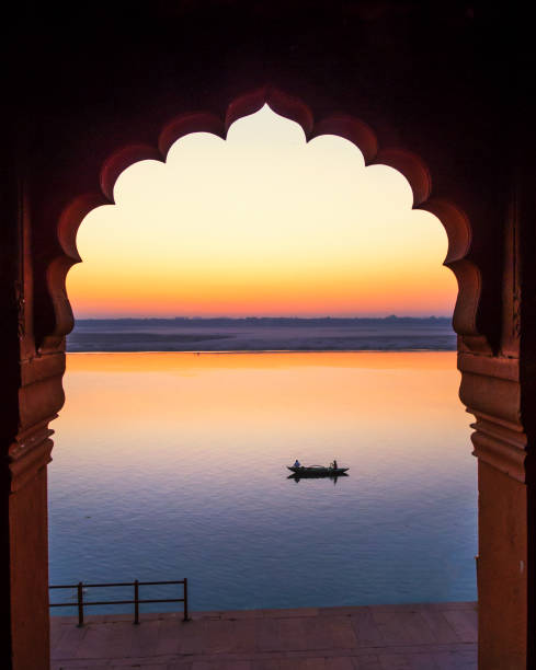 A rowing boat through an arch A single rowing boat through the arch along river Ganga at dawn ganges river stock pictures, royalty-free photos & images