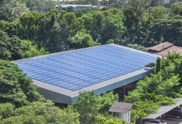 rijen matrix van polykristallijne silicium zonnecellen of fotovoltaïsche zonne-energie installatie op dak fabriek - zonnepanelen warehouse stockfoto's en -beelden