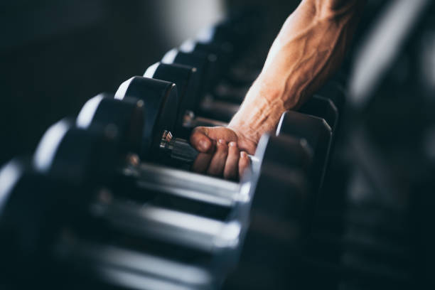 Rows of dumbbells in the gym with hand stock photo