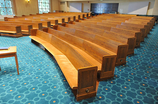 Rows of pews in a synagogue Pews in a synagogue facing the stage area with a table in front. Very shallow depth of field with focus on foreground. synagogue stock pictures, royalty-free photos & images