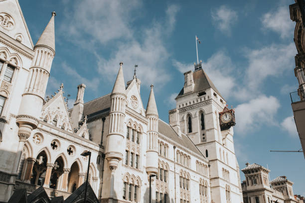 Royal Courts Justice facade during a sunny day, with blue sky and clouds in the background, in London, United Kingdom. stock photo